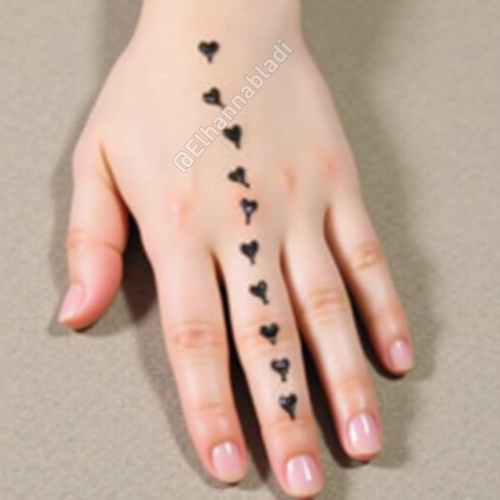 نقش بسيط للحناء يتضمن قلوبًا صغيرة متفرقة على راحة اليدين والأصابع.