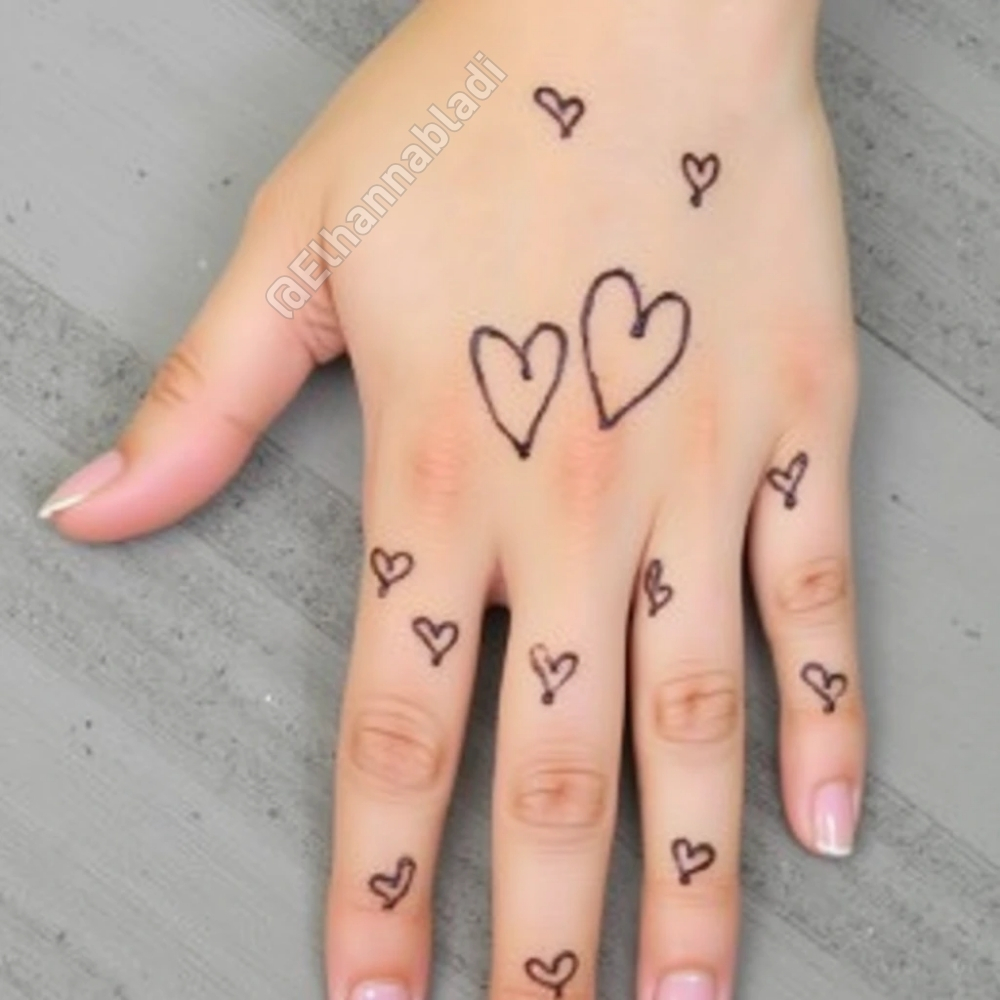 نقش بسيط للحناء يتضمن قلوبًا صغيرة متفرقة على راحة اليدين والأصابع.