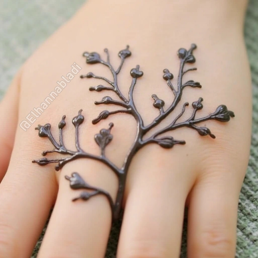 تصميم نقش مستوحى من غصن شجرة بأوراق صغيرة تمتد على طول اليد.