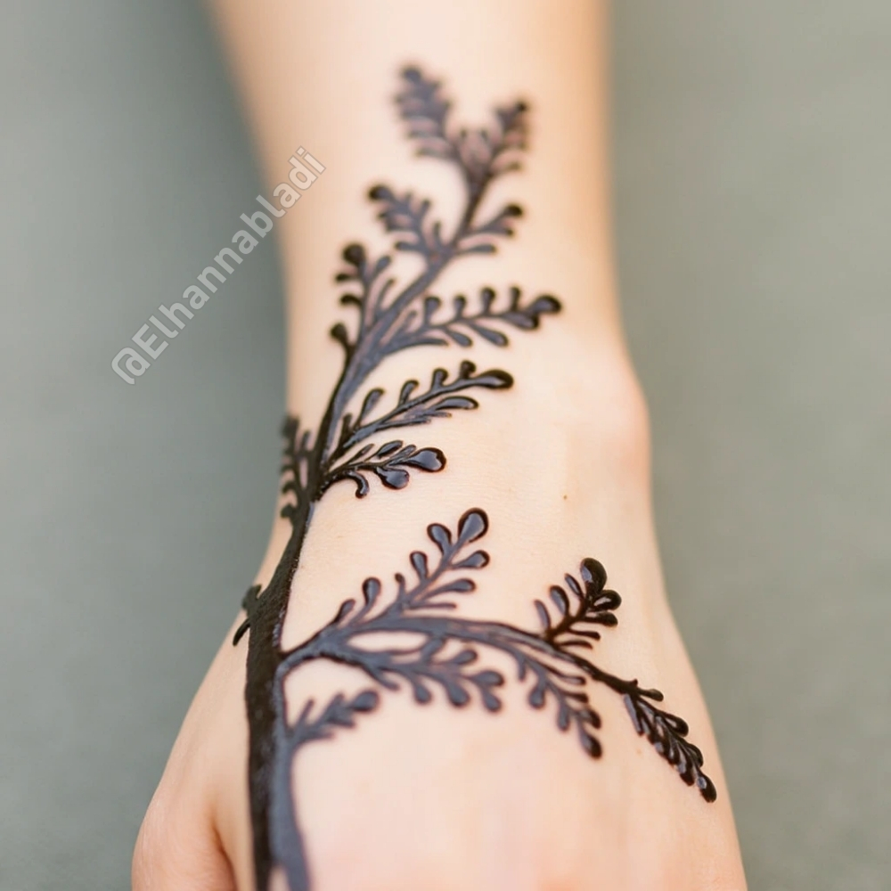 تصميم نقش مستوحى من غصن شجرة بأوراق صغيرة تمتد على طول اليد.