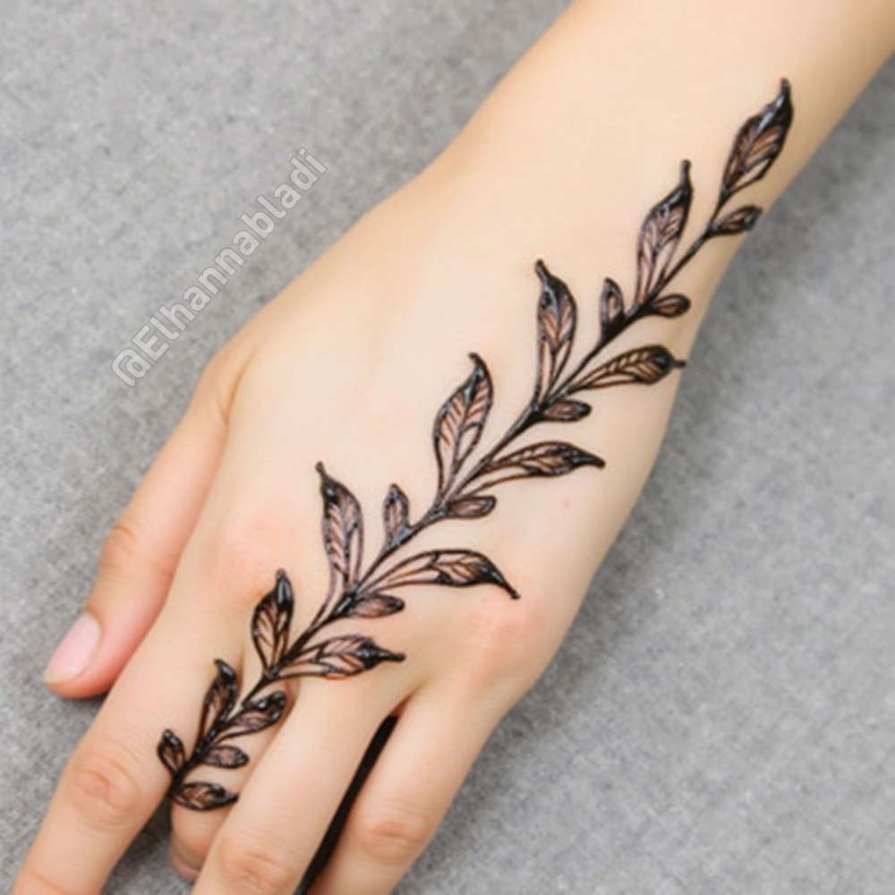 تصميم نقش مستوحى من غصن شجرة بأوراق صغيرة تمتد على طول اليد.